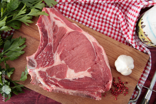 Photo: bistecca di vitello fiorentina su tagliere di legno bistecca di vitello fiorentina su tagliere di legno