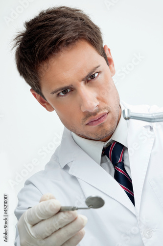 Photo: Dentist Holding Drill And Angled Mirror Dentist Holding Drill And Angled Mirror