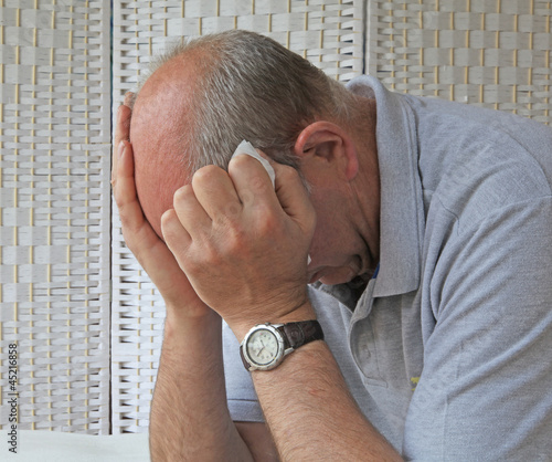 Photo: Depressed man holding tissue Depressed man holding tissue