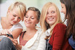 Foto: 4 girls with smartphones on the sofa 4 girls with smartphones on the sofa
