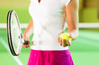 Frau spielt Tennis im Fitnessstudio