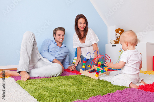 Photo: Familie spielt mit baby im kinderzimmer Familie spielt mit baby im kinderzimmer