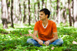 Foto: Handsome man sitting cross-legged in the woods Handsome man sitting cross-legged in the woods