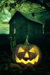 Halloween pumpkin in front of a Spooky house