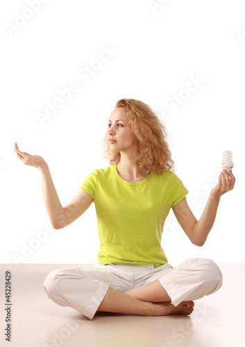 Photo: A woman with an energy-saving bulb meditating A woman with an energy-saving bulb meditating