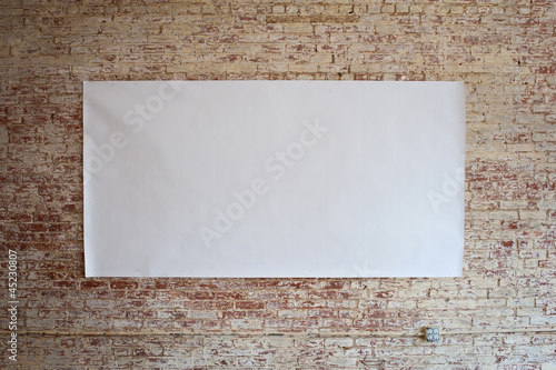 Photo: Blank billboard on brick wall. Blank billboard on brick wall.