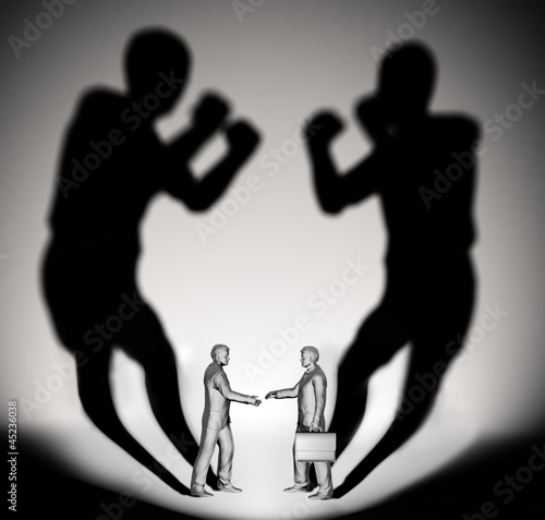 Illustration: Two businessman casting a shadow shaped like two fighters Two businessman casting a shadow shaped like two fighters