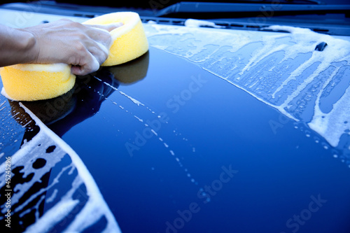 Photo: hand hold sponge over the car for washing hand hold sponge over the car for washing