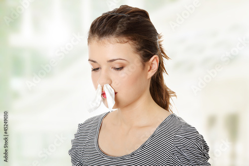 Photo: Woman with tissue in her nose Woman with tissue in her nose