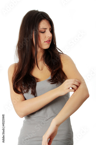 Photo: Young beautiful woman scraching her self. Young beautiful woman scraching her self.