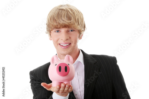 Photo: Young businessman holding piggy bank Young businessman holding piggy bank