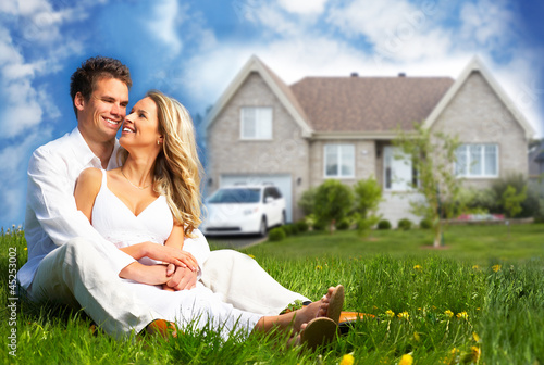 Photo: Happy family near new house. Happy family near new house.
