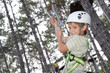young happy child boy in adventure park wearing mountain helmet