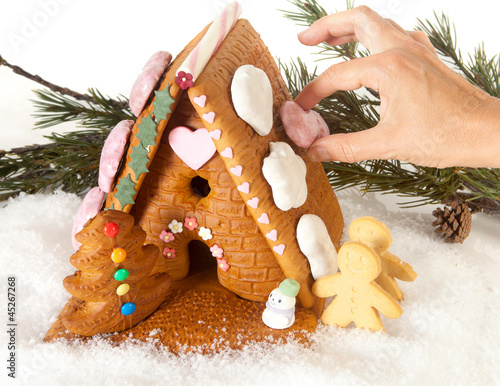 Photo: Hand decorating gingerbread house Hand decorating gingerbread house