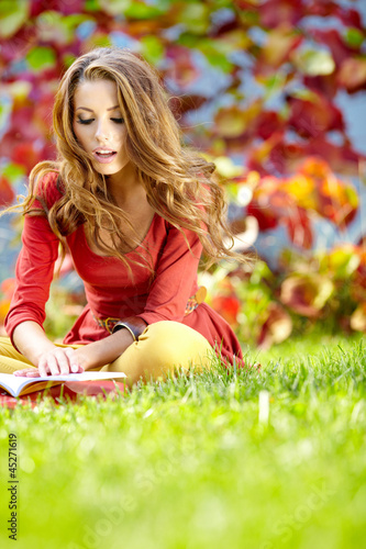 Photo: beautiful girl with book in the autumn park beautiful girl with book in the autumn park