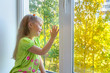 Foto: Cheerful girl sitting by the window Cheerful girl sitting by the window