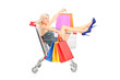 Happy woman with bags sitting in a shopping cart