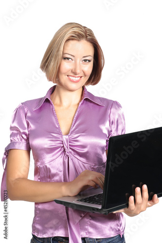 Photo: smiling young woman standing with laptop isolated on white backg smiling young woman standing with laptop isolated on white backg