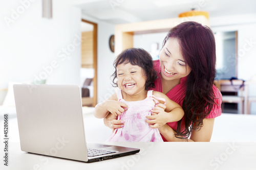 Photo: Happy family with laptop at home Happy family with laptop at home