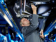 Master mechanic is checking the engine bay on a service lift