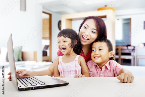 Photo: Happy family with laptop at home 1 Happy family with laptop at home 1