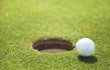 golf ball on lip of cup