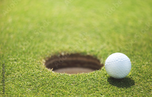 Photo: golf ball on lip of cup golf ball on lip of cup