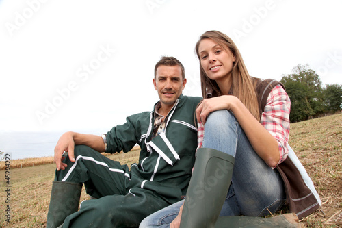Photo: Couple of farmers sitting outside in field Couple of farmers sitting outside in field