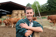 Herdsman standing in front of cattle in farm
