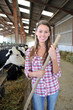 Smiling breeder woman giving food to cows