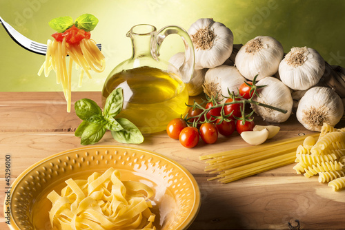 Photo: stil life with olive oil,vegetables on wood table stil life with olive oil,vegetables on wood table