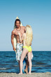 Young couple at the beach with surfboard.