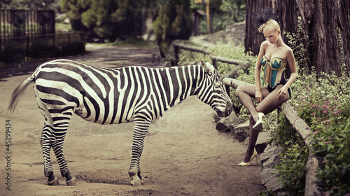 Photo: Beautiful lady sitting next to a zebra Beautiful lady sitting next to a zebra