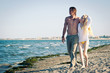 Romantic couple at the beach walking together.