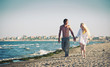 Romantic couple at the beach walking together.