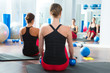 blue toning ball in women pilates class rear view