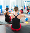  blue toning ball in women pilates class rear view