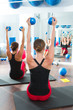  blue toning ball in women pilates class rear view