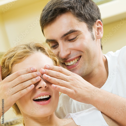 Photo: Cheerful smiling young couple, indoors Cheerful smiling young couple, indoors