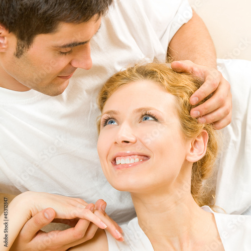 Photo: Cheerful smiling young couple, indoors Cheerful smiling young couple, indoors