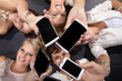 Frauen am Boden lachen mit Smart Phones