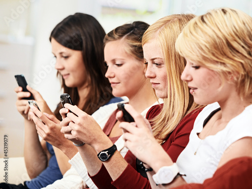 Photo: 3 girls with smartphone on the sofa 3 girls with smartphone on the sofa