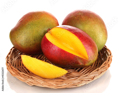 Photo: Ripe appetizing mango on wicker cradle isolated on white Ripe appetizing mango on wicker cradle isolated on white