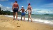 Family go for a walking along sand beach