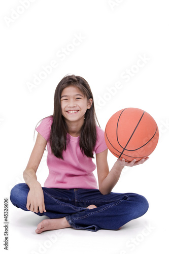 Photo: Young girl holding basketball, isolated on white Young girl holding basketball, isolated on white