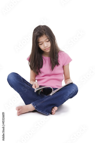 Photo: Little girl sitting on floor reading a magazine Little girl sitting on floor reading a magazine