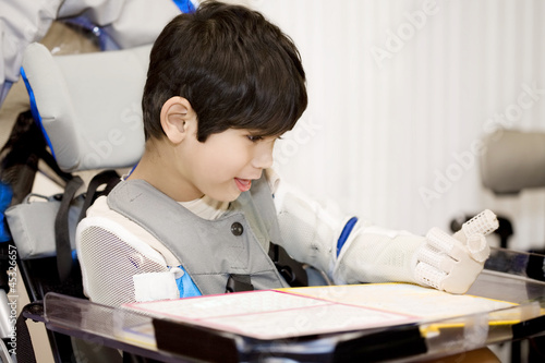 Photo: Five year old disabled boy studying in wheelchair Five year old disabled boy studying in wheelchair