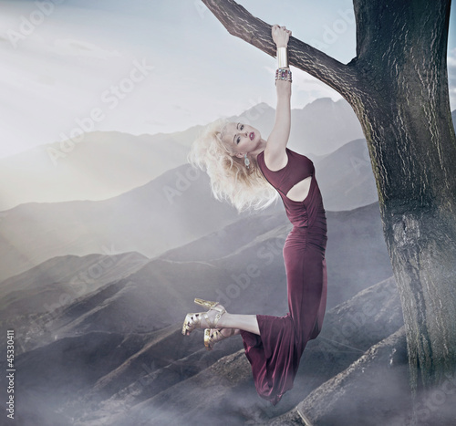 Photo: Attractive blonde lady hanging on a tree Attractive blonde lady hanging on a tree