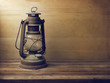 Vintage kerosene lamp on wooden table and wooden background