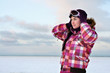 Photo: Beautiful young woman wearing skiing suit posing outdoors in win Beautiful young woman wearing skiing suit posing outdoors in win